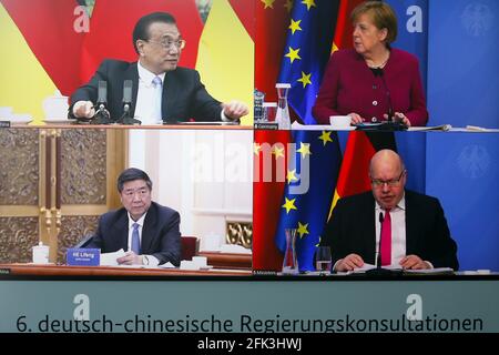 Berlin, Germany. 28th Apr, 2021. German Chancellor Angela Merkel and German Economics Minister Peter Altmaier (both CDU - bottom right) are seen on a television screen in the Chancellery. They are taking part in talks with Chinese Premier Li Keqiang (top left) and the Chairman of China's National Development and Reform Commission (NDRC), He Lifeng, as part of the sixth Sino-German intergovernmental consultations. This time, for the first time, there was only one video conference due to the Corona pandemic. Credit: Michele Tantussi/Reuters/Pool/dpa/Alamy Live News Stock Photo