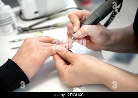 Mens manicure. A manicure master makes a hardware manicure for a man in the salon. Beauty industry. Stock Photo