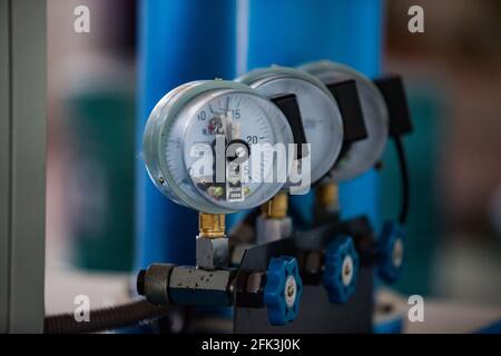 Close-up of manometer gauges and blue pipes. Low depth of field. Blurred background. Stock Photo