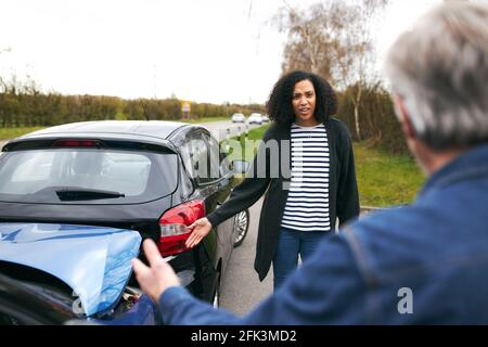 Senior male driver arguing over blame for car accident with a younger female motorist Stock Photo