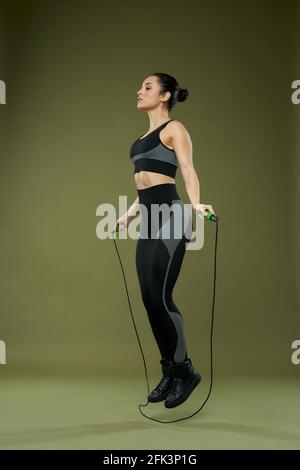 Young sportswoman doing jump rope workout in gym Stock Photo - Alamy