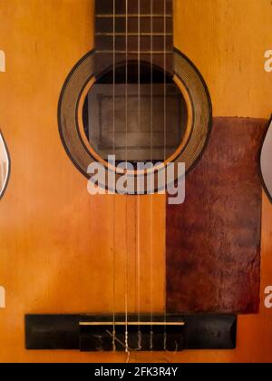 Detail of an old and deteriorated Spanish guitar with a missing string ...