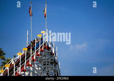 Passenger cars reaching the peak of the world's only still operating wooden roller coaster 'Giant Dipper' in Santa Cruz Beach Bordwalk, CA. Stock Photo