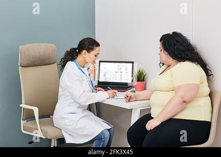 Obesity, unhealthy weight. Nutritionist calculating body mass index of fat woman for obesity treatment Stock Photo