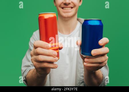 Close up man holds cans, isolated on green background Stock Photo
