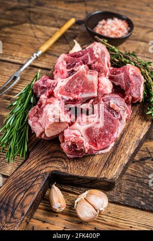 https://l450v.alamy.com/450v/2fk400p/raw-beef-meat-diced-for-stew-with-bone-wooden-background-top-view-2fk400p.jpg