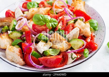 Traditional italian tomato salad panzanella with mozzarella, capers, red onion and croutons. Summer salad. Stock Photo