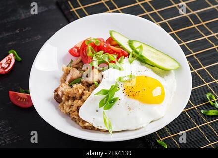 Nasi Goreng. Indonesian chicken fried rice on dark background. Nasi Goreng is an indonesian cuisine dish with rice, chicken meat, onion, egg, vegetabl Stock Photo