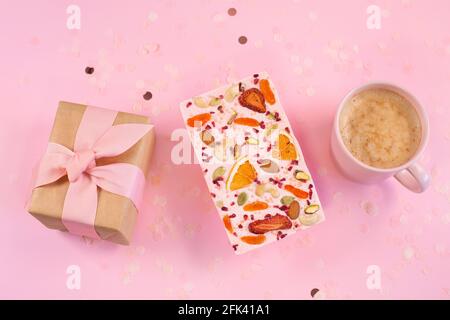 View of Cup of Coffee and Handmade pink chocolate and gift box on a fastive Pink Background. Greeting card concep Stock Photo