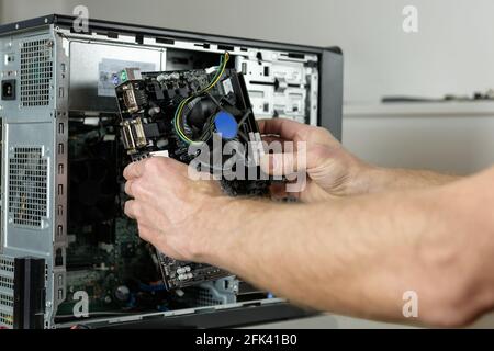 A technician is installing the motherboard in the desktop case. Stock Photo