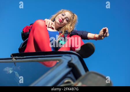 Beautiful girls in the style of the 90s in bright clothes against the blue sky. Stock Photo