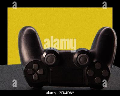 Control of new generation electronic games. Black game controller isolated on blue background. Gamepad. Wireless joytsick for PC games. Stock Photo