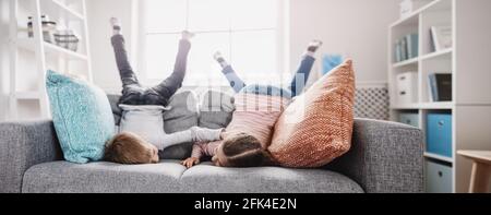 Cute children lying face down on the sofa Stock Photo