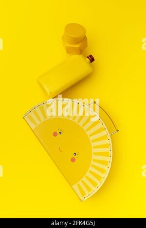 Yellow case, bottle and container construction hovering on a yellow background. Creative top view, floating. Stock Photo
