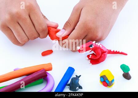 Child playing and creating toys from play dough. Child molding modeling clay. Strengthen the imagination of child. Stock Photo