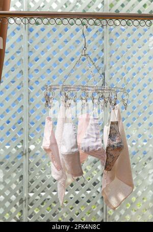 Cloth masks hanging on the cloth hanger with clothspins, reuseing cloth masks Stock Photo