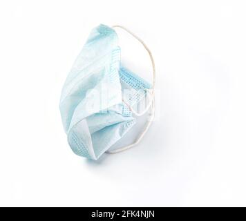 Used blue medical surgical mask, Medical protective mask on white background. Disposable surgical face mask cover the mouth and nose. Stock Photo
