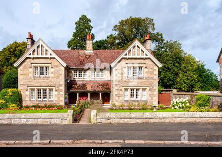 Neat, well maintained, modern, semi-detached cottages in the village of Ford each with a large front garden with green lawns and flower beds Stock Photo