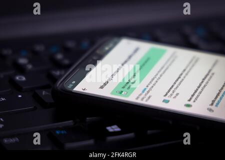 WhatsApp Terms of Service on a smartphone against a PC computer. Stock Photo