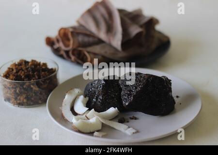 Palm jaggery and sliced coconut. A natural sweet combination. Shot on white combination. Stock Photo