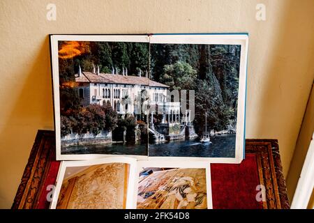 Open book with a photo of a beautiful building stands on the table against the background of the wall Stock Photo