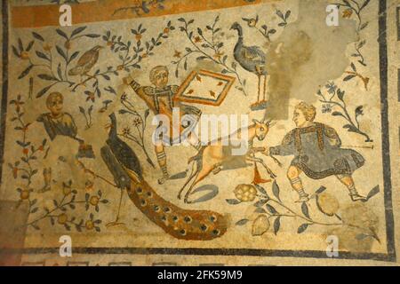Ancient Roman mosaic of a boy spearing a goat with a peacock. From the UNESCO listed Ancient Roman mosaics in the Villa Romana del Casale, Sicily Stock Photo