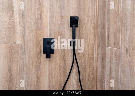 New black shower head on holder in white tiled bathroom in modern apartment  Stock Photo - Alamy