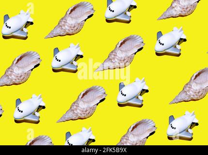 Pattern of toy airplanes and seashells on yellow background. Travel on summer vacation Stock Photo