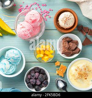 Cream, raspberry, blackberry and mango ice cream on a light blue background. Stock Photo