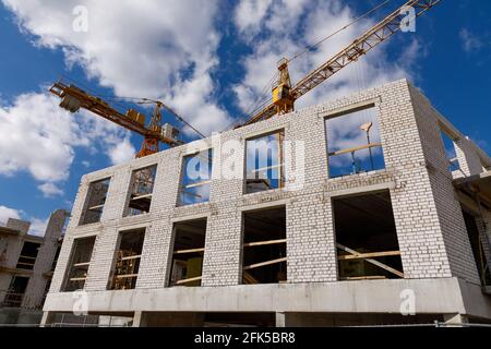 Unfinished construction of a multi-store residential building and a tall crane. The photo is taken in Vilnius, Lithuania. Stock Photo