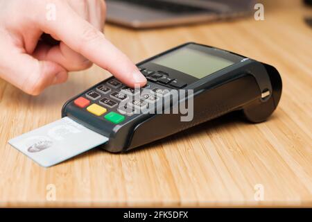 Man hand enters pin code on the terminal for payment. Stock Photo