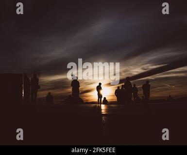 Sunset silhouettes of the people at the roof Stock Photo