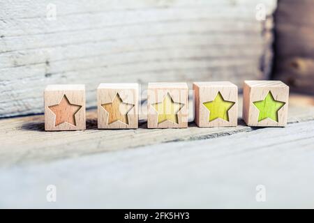 5 Star Ranking From Red To Green Written On Wooden Blocks On A Board - Quality Concept Stock Photo