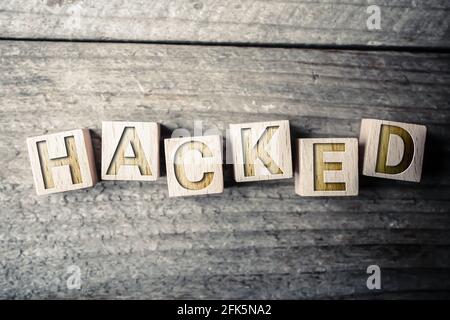 Hacked Written On Wooden Blocks On A Board Stock Photo