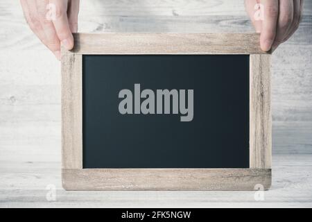 2 Hands Holding A Blank Blackboard With Copy Space In Front Of A Background Stock Photo