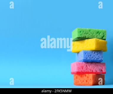 multicolored sponges cleaning kit isolated on blue background Stock Photo