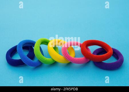 Scrunchies, Colored elastic baby hair ties, cotton hair kids ponytail holders, seamless hair bands on blue background. Stock Photo
