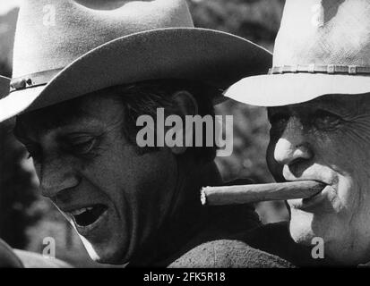 STEVE McQUEEN and Director HENRY HATHAWAY on set location candid during filming of NEVADA SMITH 1966 director HENRY HATHAWAY based on character created by Harold Robbins in The Carpetbaggers story / screenplay John Michael Hayes Solar productions / Paramount Pictures Stock Photo