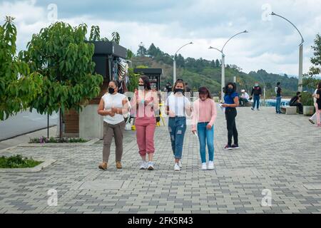 Guatapé, Antioquia, Colombia - April 4 2021: Latin Women of Different Ages Walking in a Horizontal Line Chatting with Each Other in the Plaza Stock Photo