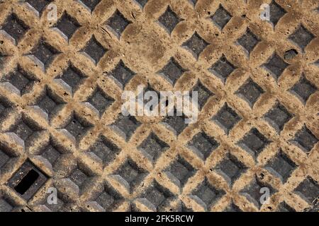 Metal cap on the road after rain in close up. Stock Photo