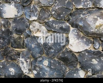 Close-up of a flint stone wall on a Suffolk church; a traditional building material where the flints are knapped or cut & shaped to size. Stock Photo