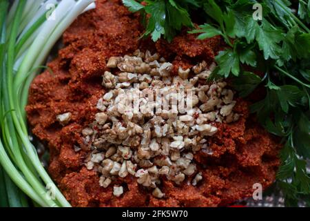 Turkish raw meatballs (Cig kofte; a raw meat dish) with salad, onion and tomato. Close up Stock Photo