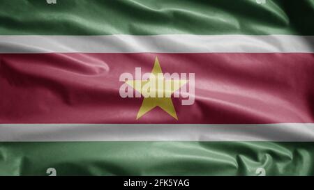 Surinamese flag waving in the wind. Close up of Suriname banner blowing, soft and smooth silk. Cloth fabric texture ensign background. Stock Photo