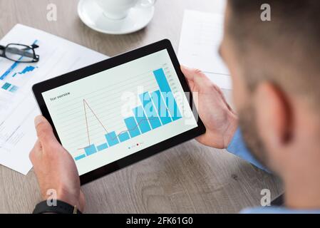 Businessman using tablet computer at work. Financial, analytics chart on tablet Stock Photo
