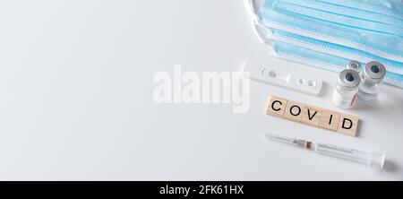 Vaccination concept, coronavirus vaccination, medical equipment, COVID word from wooden tiles Stock Photo