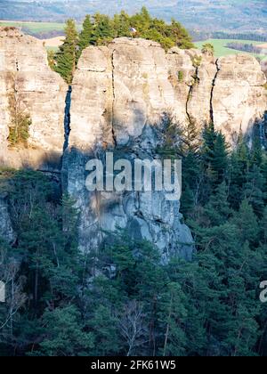 Czech flag at the top of the rock and climer in the wall. Sandstone rocks at the north of Bohemia. Memorable place for climbers Stock Photo