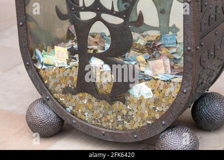 Krakow. Poland. Spring 2019. Large collection container in Krakow Castle. Polish zloty, Euro and other cash in a glass container. Stock Photo