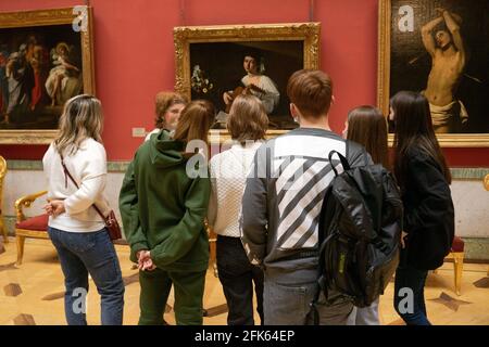 Tour guide talking to a group of visitors about Caravaggio's 'Lute Player' painting in Hermitage museum, St. Petersburg, Russia Stock Photo