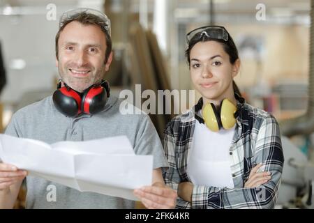 mature male worker with young female apprentice in workplace Stock Photo