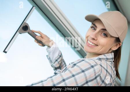 woman cleaning windows with a squeegee Stock Photo